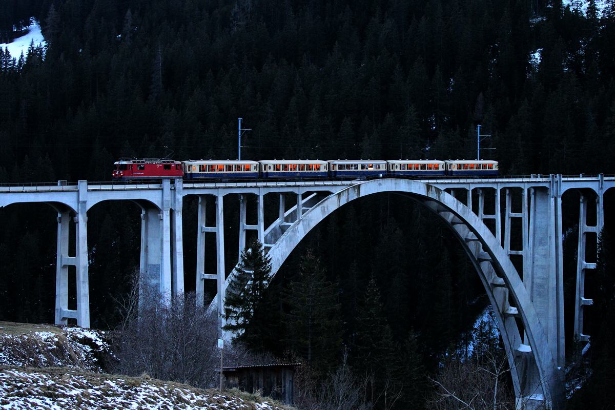 Ge 4/4 II 625 fährt mit dem Alpine Pullmann Classic anlässlich der 100 Jahr Feier,Strecke Chur-Arosa im allerletzten Büchsenlicht über das Langwieser Viadukt aus Arosa zurückkommend Richtung Chur.Bild vom 13.12.2014