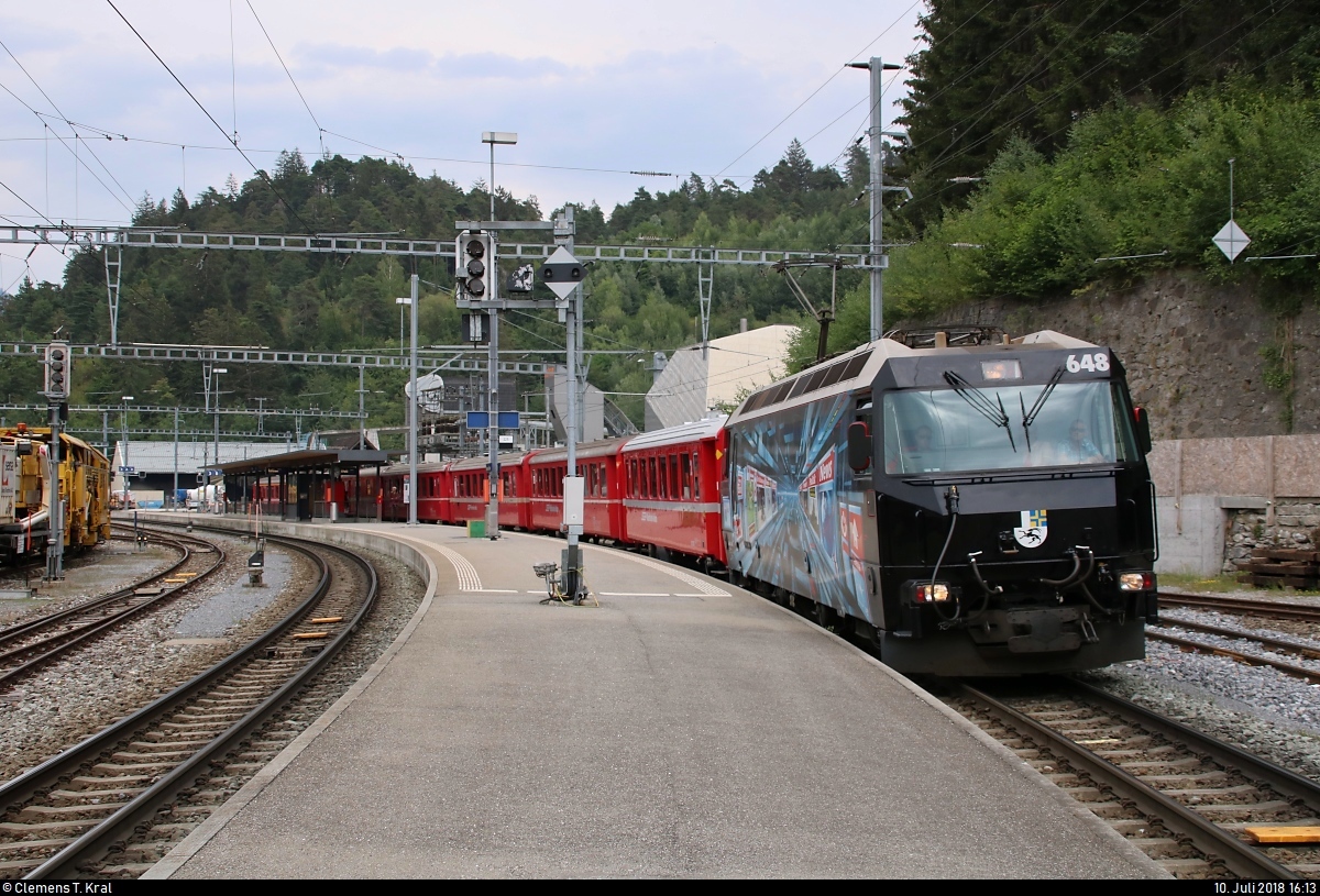 Ge 4/4 III 648  Susch  mit Werbung für die Zeitung  Blick  der Rhätischen Bahn (RhB) als IR 1153 von Chur (CH) nach St. Moritz (CH) verlässt den Bahnhof Reichenau-Tamins (CH) auf Gleis 4.
[10.7.2018 | 16:13 Uhr]