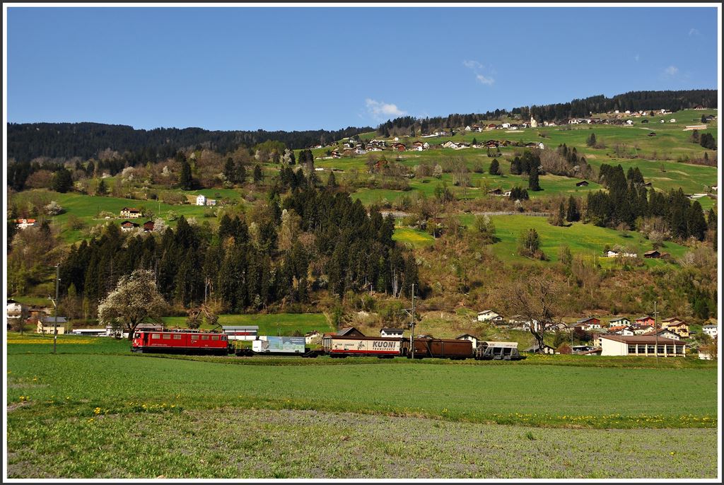 Ge 6/6 II 702  Curia  zieht am Fuss des Heinzenbergs bei Cazis einen Güterzug Richtung Thusis. (23.04.2015)