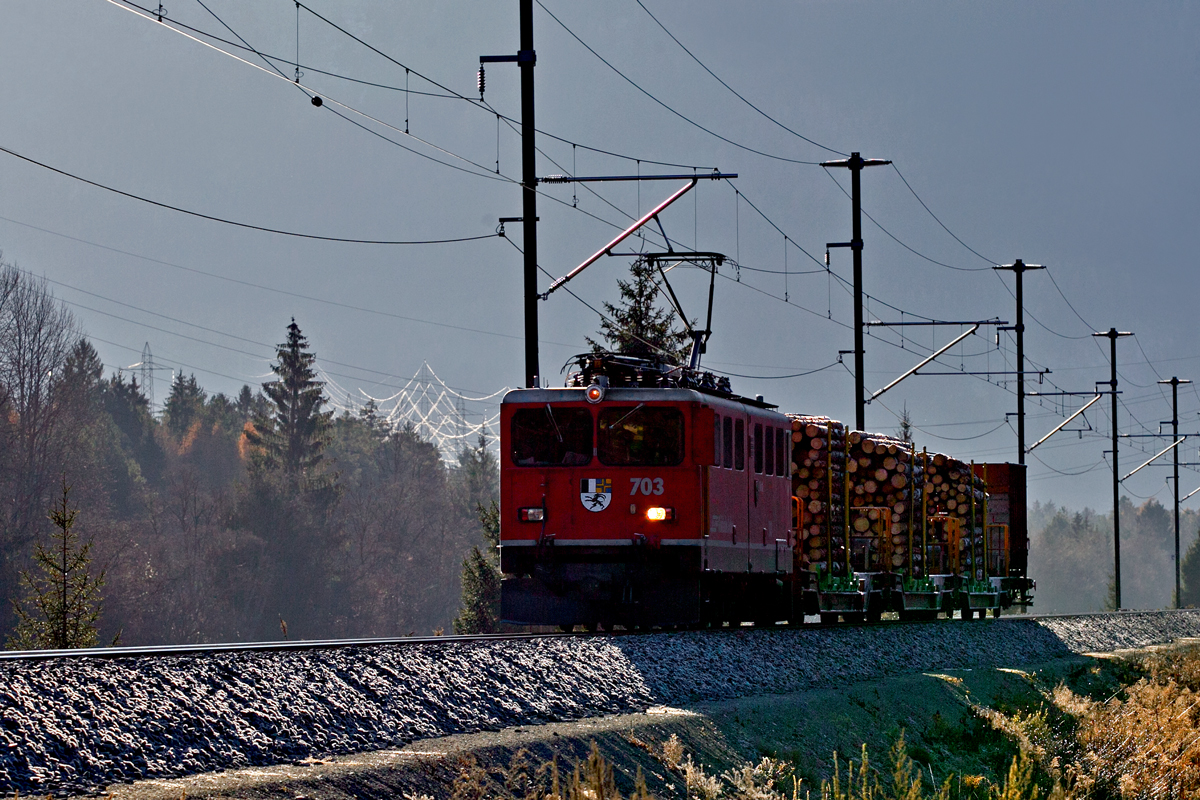Ge 6/6 II 703  St.Moritz  befördert im Gegenlicht Holz talwärts bei Realta vorüber.bild 8.12.2015