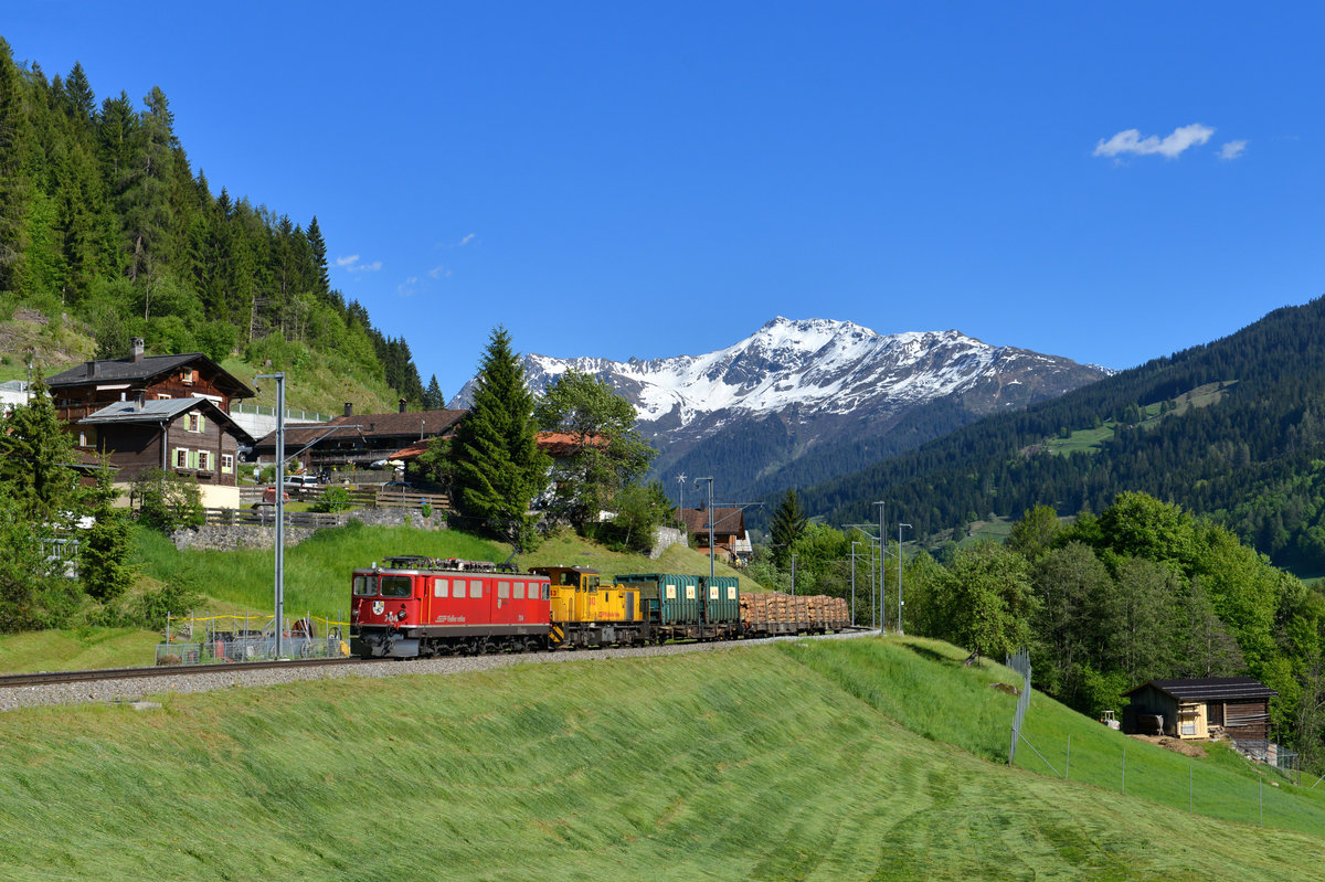 Ge 6/6 II 704 + Gmf 4/4 243 mit einem Güterzug am 26.05.2017 bei Serneus. 