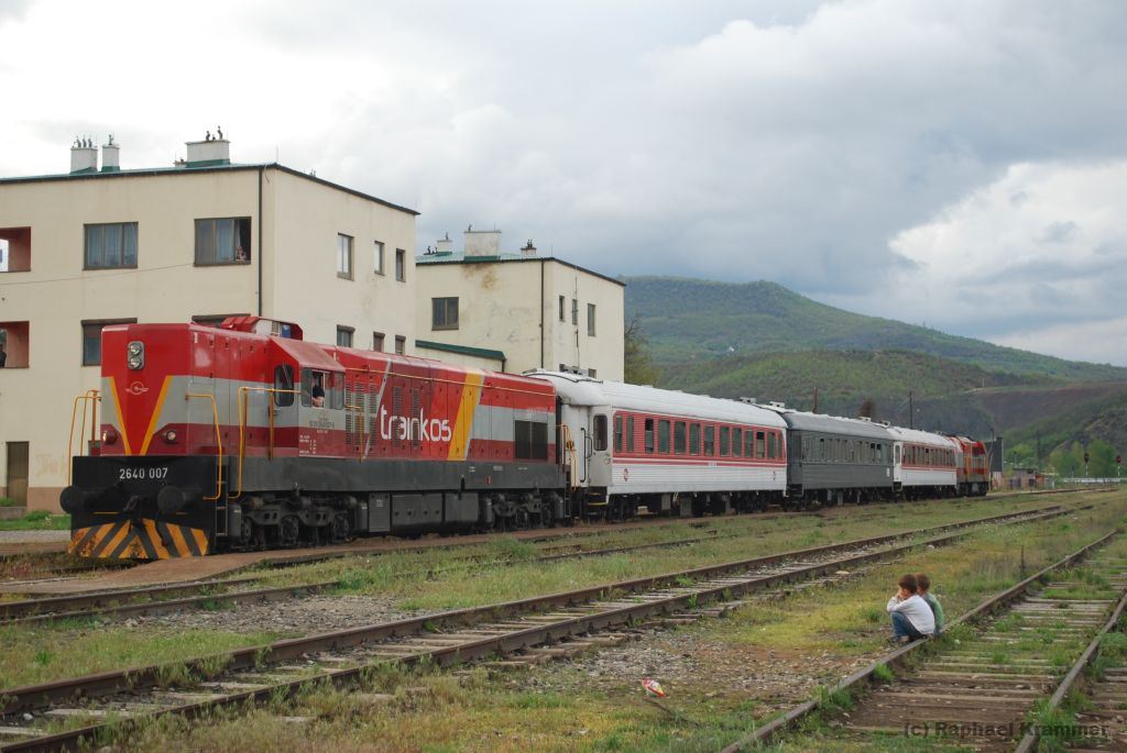 Gebannt sehen sich zwei Jungs einen Sonderzug am 26.04.14 in Mitrovica an. Güterzuglok 003 (alias 2640 007) wartet derweil auf die Rückfahrt nach Fushe Kosove (srb.: Kosovo Polje). Hinten am Zug befindet sich die Güterzuglok 010. Ob die Jungs irgendwann wieder regulären Personenverkehr in Mitrovica erleben, steht in den Sternen.