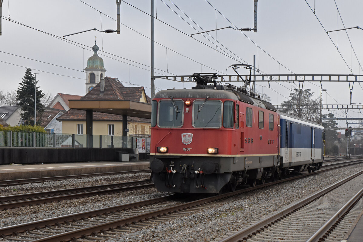 Gefängniszug, mit der Re 4/4 II 11200 und dem St 50 85 89-33 900-3 durchfährt den Bahnhof Rupperswil. Die Aufnahme stammt vom 04.02.2022.