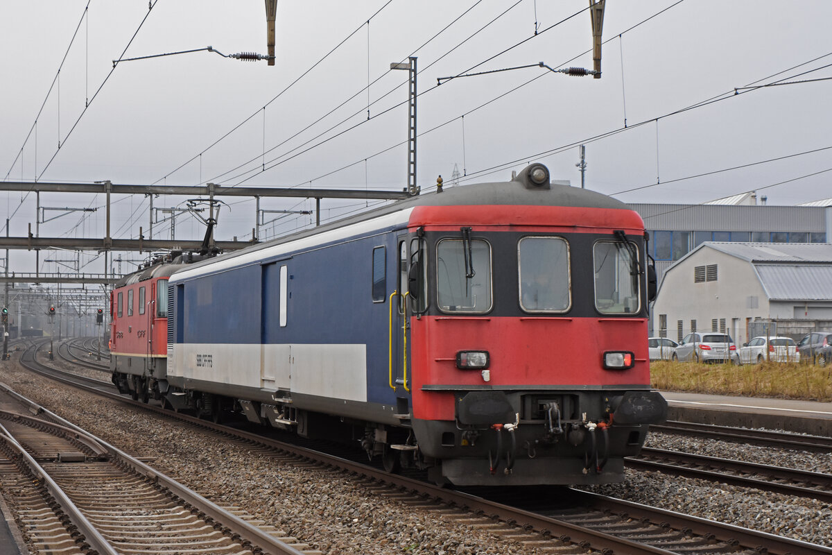 Gefängniszug, mit der Re 4/4 II 11200 und dem St 50 85 89-33 900-3 durchfährt den Bahnhof Rupperswil. Die Aufnahme stammt vom 04.02.2022.