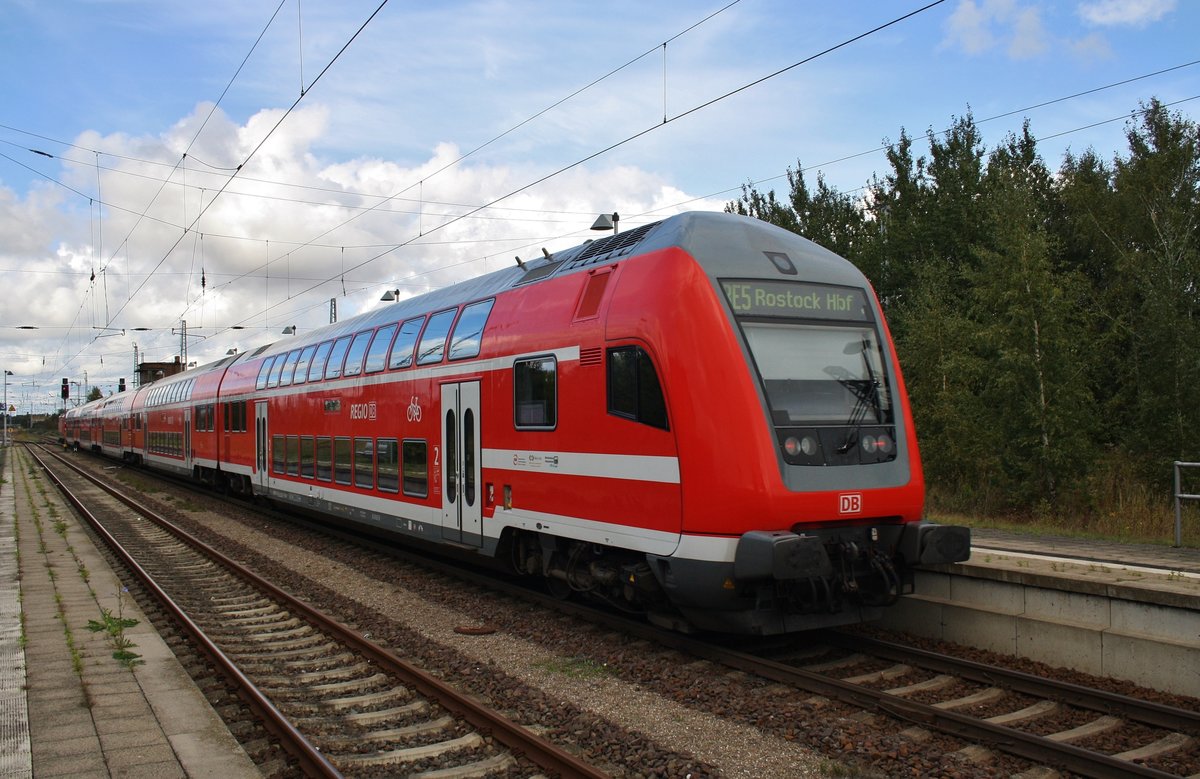 Geführt von 112 107 verlässt der RE5 (RE4356) von Wünsdorf-Waldstadt nach Rostock Hauptbahnhof am 8.10.2016 Güstrow. 