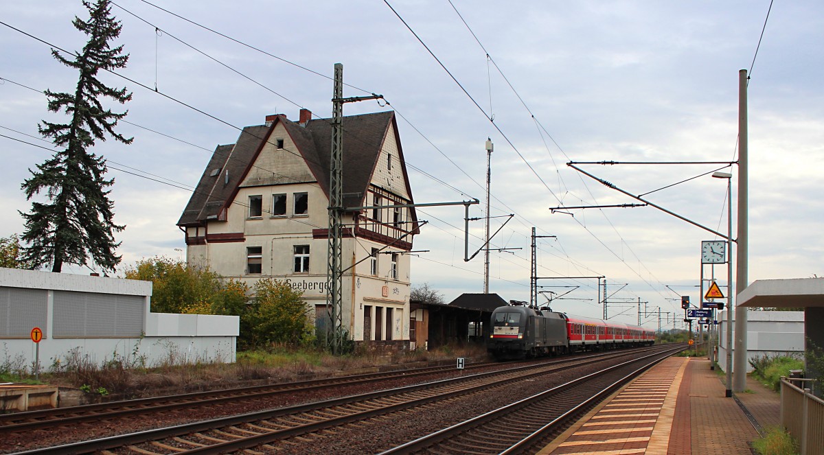 Gegenüber dem leerstehendem Empfangsgebäude von Seebergen sieht die RB 16312 richtig klein aus. ES 64 U2-013 (182 513-2) fährt am 10.10.2014 mit ihrer Regionalbahn in den selbigen Haltepunkt ein.