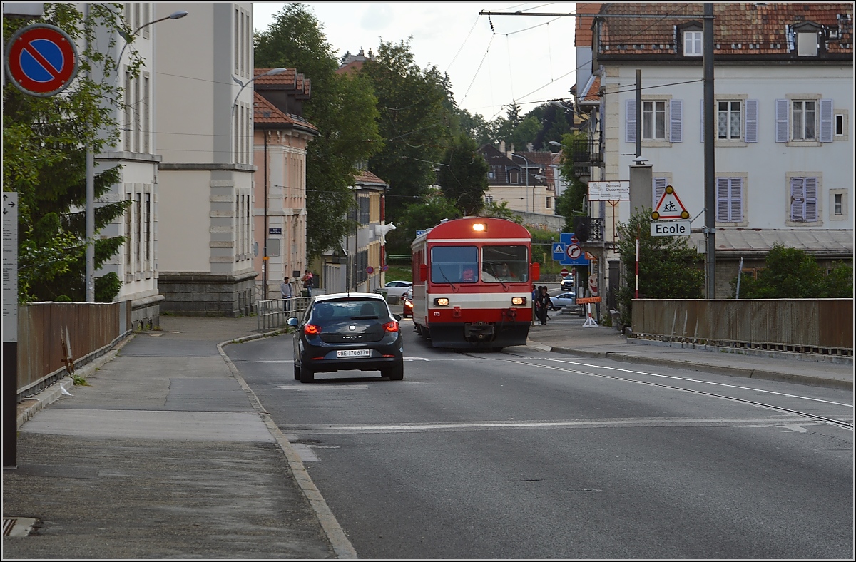 Geisterfahrer BDe 4/4 613 der CJ in der Rue de Manège in La-Chaux-de-Fonds. Wenn man genau hinschaut, fährt der Zug auf der falschen Seite der Strasse, der Autoverkehr muss auf Gegenseite ausweichen. Hinter dem Zug herfahren ist daher schwierig, denn es geht nur voran, wenn man den Gegenverkehr durchlässt. Juli 2016.