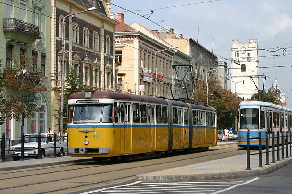 Gelenktriebwagen 491 ist am 25.08.2005 in der Stadtmitte von Debrecen unterwegs. Die Ablsung verkehrt schon im Gegenverkehr.