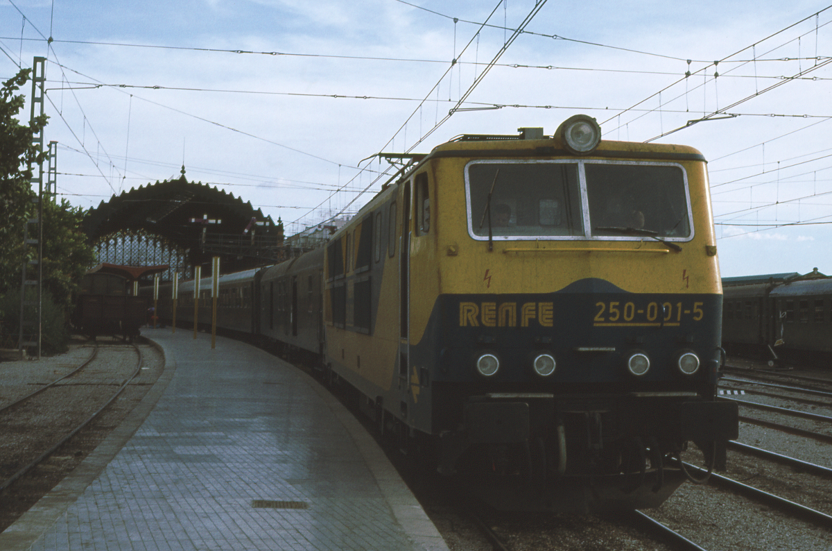 Gerade erst zwei Jahre alt war die bei Krauss Maffei in München gebaute 250 001, als ich sie im Oktober 1982 in Sevilla Plaza Armas - auch Estacion de Cordoba genannt - fotografieren konnte. Sie steht abfahrbereit mit dem Expreso 991/990 Sevilla 18.20 - Barcelona Sants 10.29. 16 Stunden benötigt der Zug für 1129 km durch Spanien. Der Bahnhof ist heute ein Museum.
Oktober 1982. Canon AE1, Canoscan, GIMP.