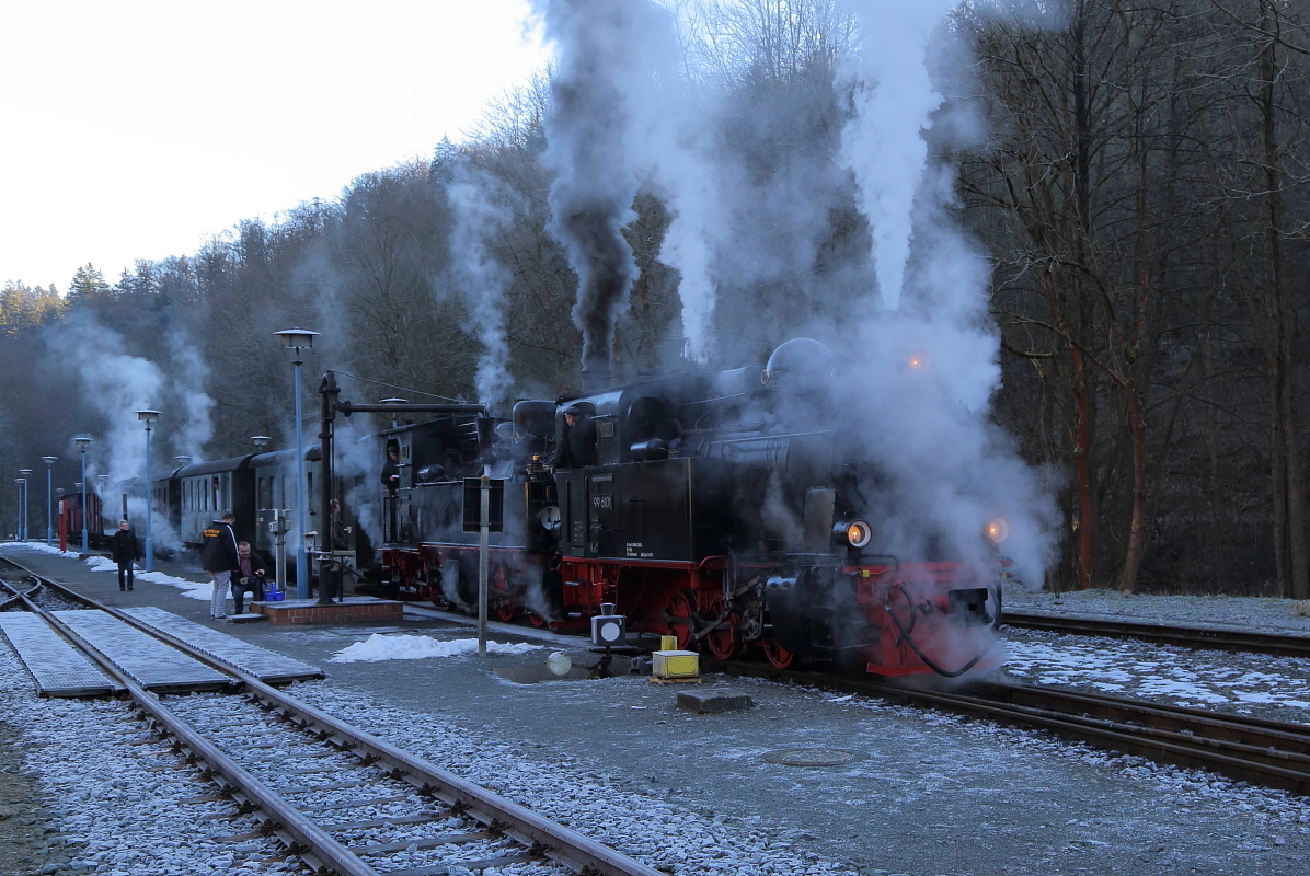 Gerade sind 99 6101 und 99 5901 am 14.02.2015 mit ihrem IG HSB-Sonder-PmG im Bahnhof Alexisbad eingetroffen und nehmen Wasser. Danach wird der Zug getrennt. 99 6101 übernimmt die Güter- und 99 5901 die Personenwagen. Es folgt eine Doppelausfahrt der beiden Züge.