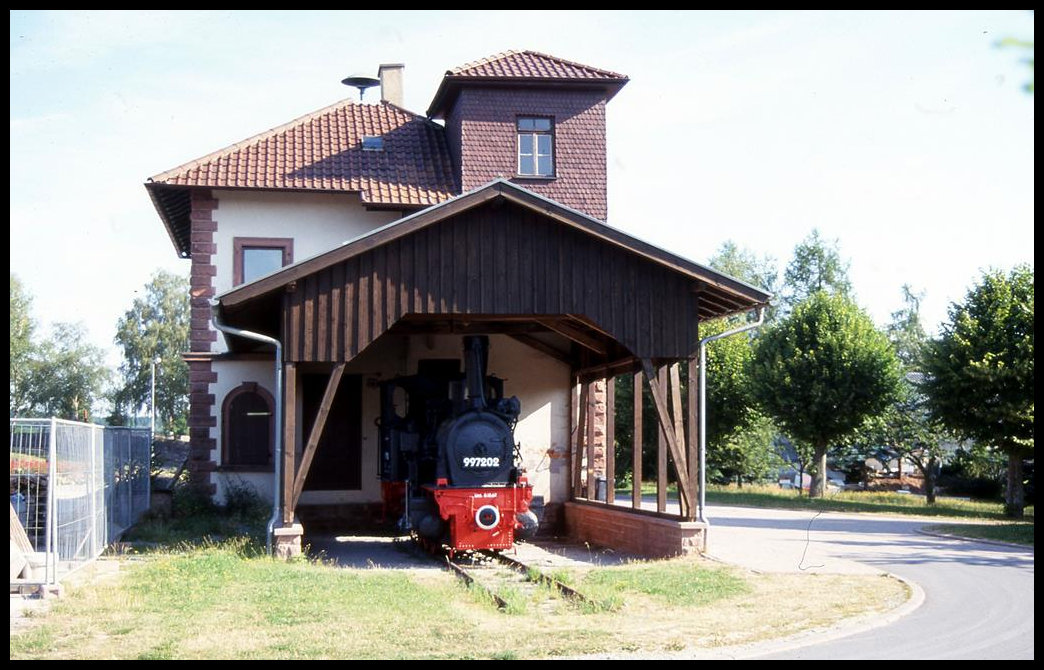 Geschützt unter einem Holzdach stand am 2.8.1999 die Dampflok 997202 der ehemaligen Bundesbahn Strecke Mosbach - Mudau am früheren Bahnhof in Mudau. Die Strecke wird heute zum größten Teil als Wanderbahn von Radfahrern und Fußgängern genutzt.