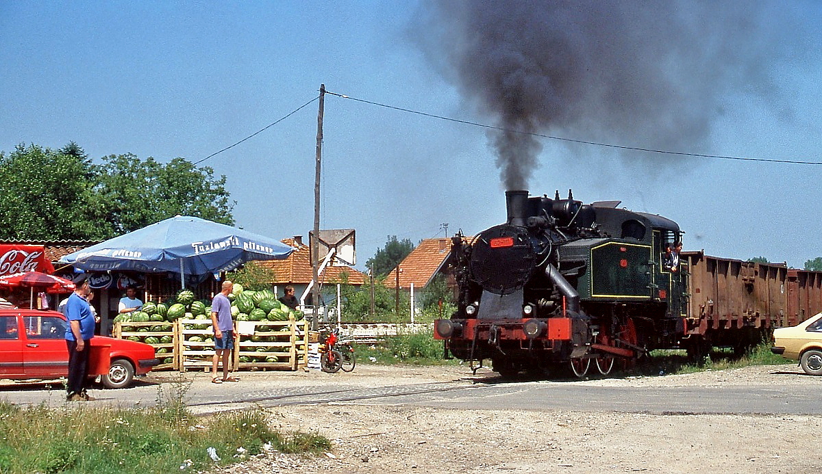 Gesichert durch den Heizer überquert 62-111 auf ihrer Fahrt zur Kohlemine Durdevik im Sommer 2005 einen Bahnübergang in Zivinice