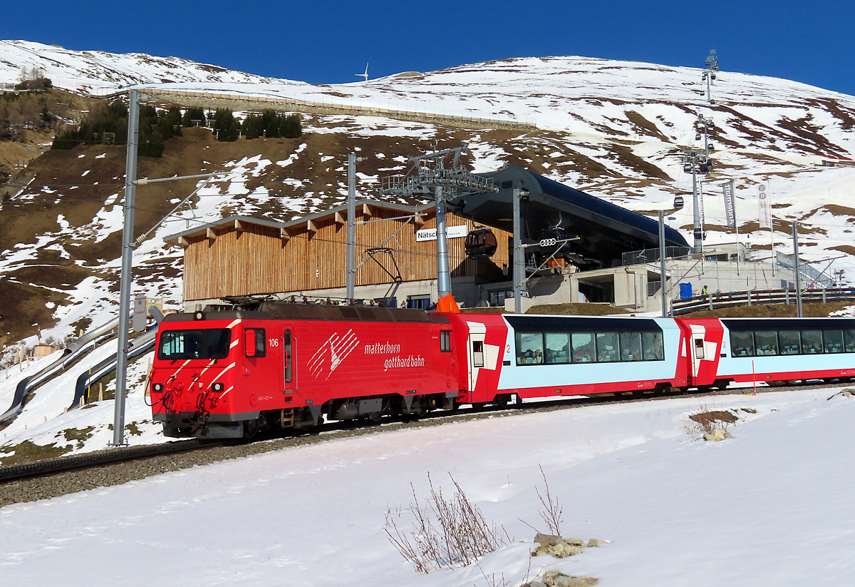 Glacier-Express mit den Panoramawagen von St. Moritz nach Zermatt fährt kurz nach der Station Nätschen (1825 müM) in einer engen Linkskurve auf dem Zahnstangenabschnitt talwärts nach Andermatt. 13.2.2023