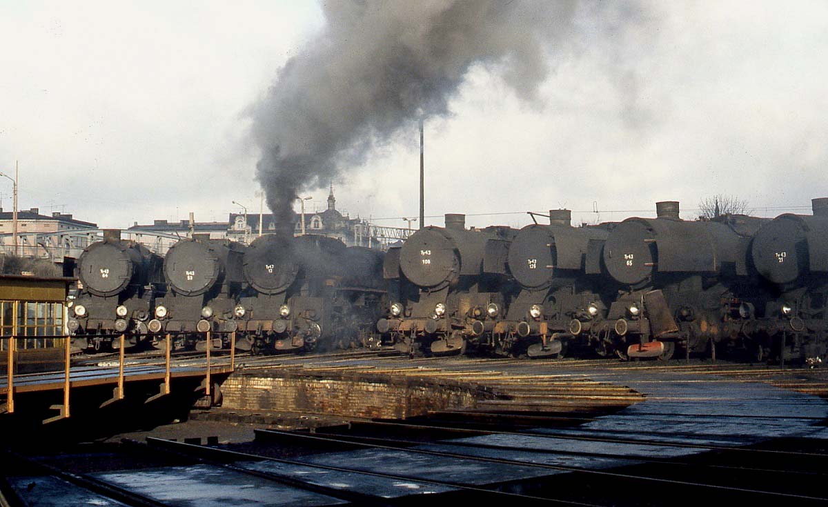 Gleich sieben Ty43 sind an der Drehscheibe des Bahnbetriebswerkes Gniezno abgestellt, die meisten dürften allerdings schon länger nicht mehr im Einsatz gewesen sein, denn im Februar 1989 wurden nur noch wenige dieser Nachbauten der Reichsbahn-Baureihe 42 für einige  Kirchtumfahrten  rund um Gniezno benötigt. Die Ty43 17, die gerade von der Drehscheibe gerollt ist, steht heute im Eisenbahnmuseum in Warschau.