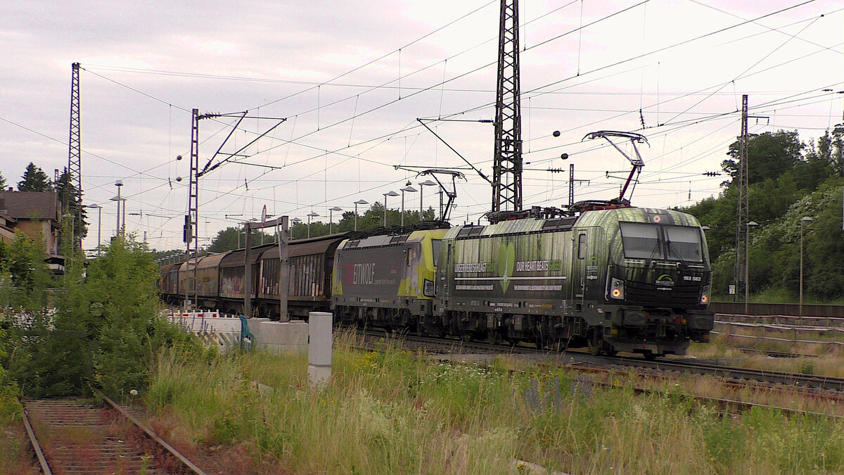 Gleich zwei auffällig beklebte TXL-Loks fahren am 20.06.2021 durch Flieden. 193 582  Unser Herz schlägt grün  und 193 554-3  Leitwolf  sind mit einem H-Wagenzug Richtung Süden unterwegs.
(Das Bild wurde gemacht ohne ein Gleis zu betreten und ohne sich im Gefahrenbereich aufzuhalten!)