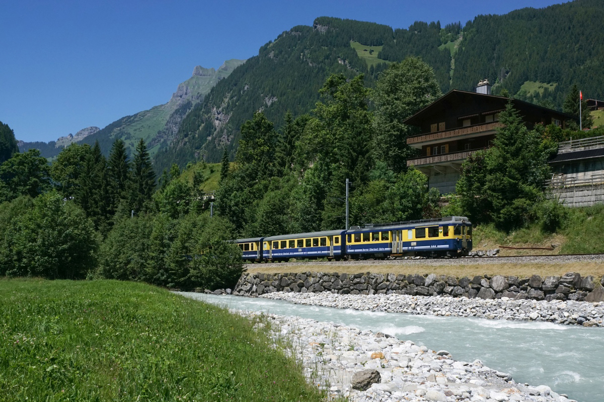 Gleiche Stelle, andere Perspektive: Ein Regionalzug Richtung Grindelwald mit dem ABeh 4/4 I 310 an der Spitze fährt am 18.06.2017 bei Schwendi der Schwarzen Lütschine entlang.
