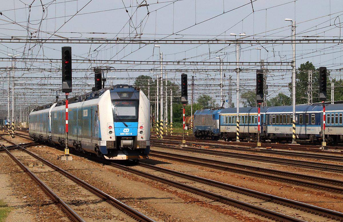 Gleichzeitige Ausfahrt eines 'InterPanters' und eines lokbespannten Reisezuges in Richtung Norden. Breclav, 12.6.2023