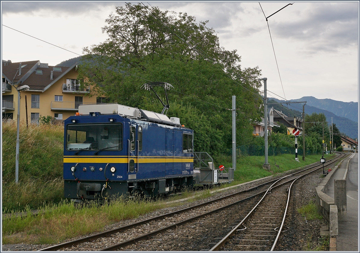 Gleisbauarbeiten bei der CEV; Die MOB Gem 2/2 2504 wartet in Blonay auf einen neuen Einsatz. 
Überraschend gut passen zur modernen Lok im Hintergrund die Hippsche Wendescheibe sowie die Weichenlaterne der Blonay Chamby Bahn. 

26. August 2020