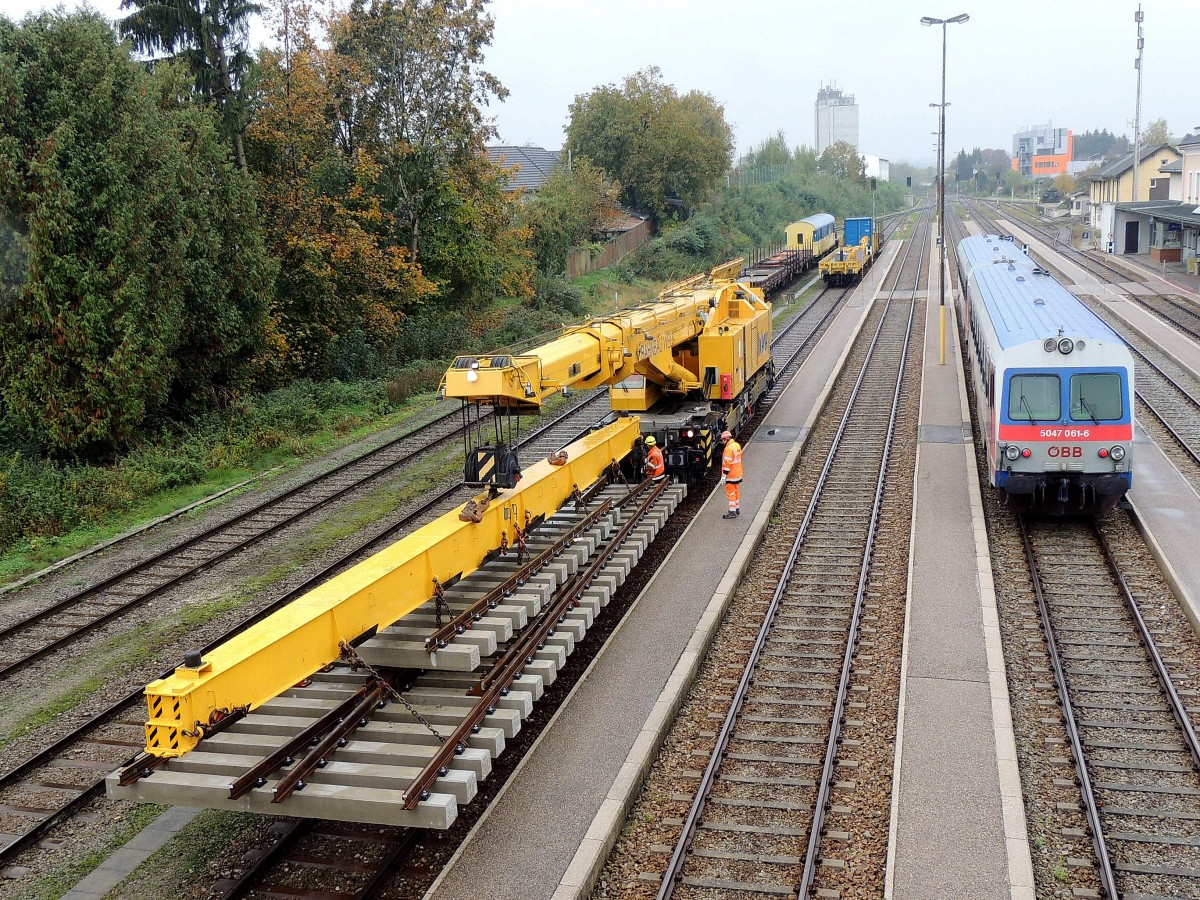 Gleisbaukran-KRC1200_99819119002-9 setzt sich am Bhf. Ried bei regnerischem Wetter mit einer Weiche zur ca. 3 Kilometer entfernten Einbaustelle in Fahrt; 151016