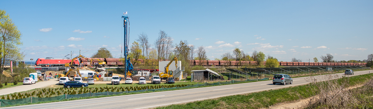 Gleisbaustelle zwischen Plattling und Osterhofen am 09.04.2017. Während des Neubaus kleinerer Brücken besteht eingeschränkter, eingleisiger Verkehr. Eine nicht identifizierte Lök der BR 185 zieht einen langen Ganzzug aus Schüttgutwagen durch den Baustellenbereich in Richtung Plattling.