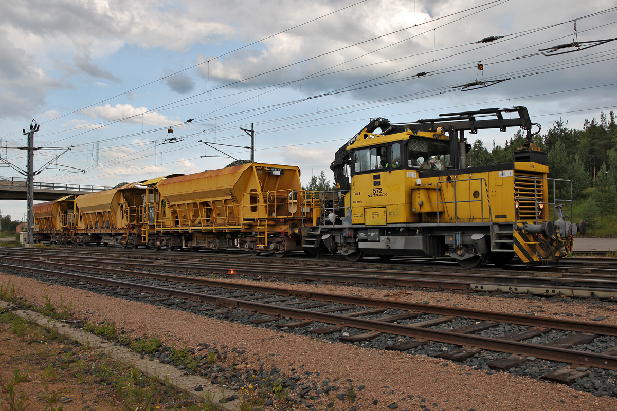 Gleisinstandhaltungsfahrzeug Tka 8  572 der VR Track mit 3 vollen Schotterwagen nach der Beladung
durch einen Pneubagger in Rovaniemi am 22.7.2014