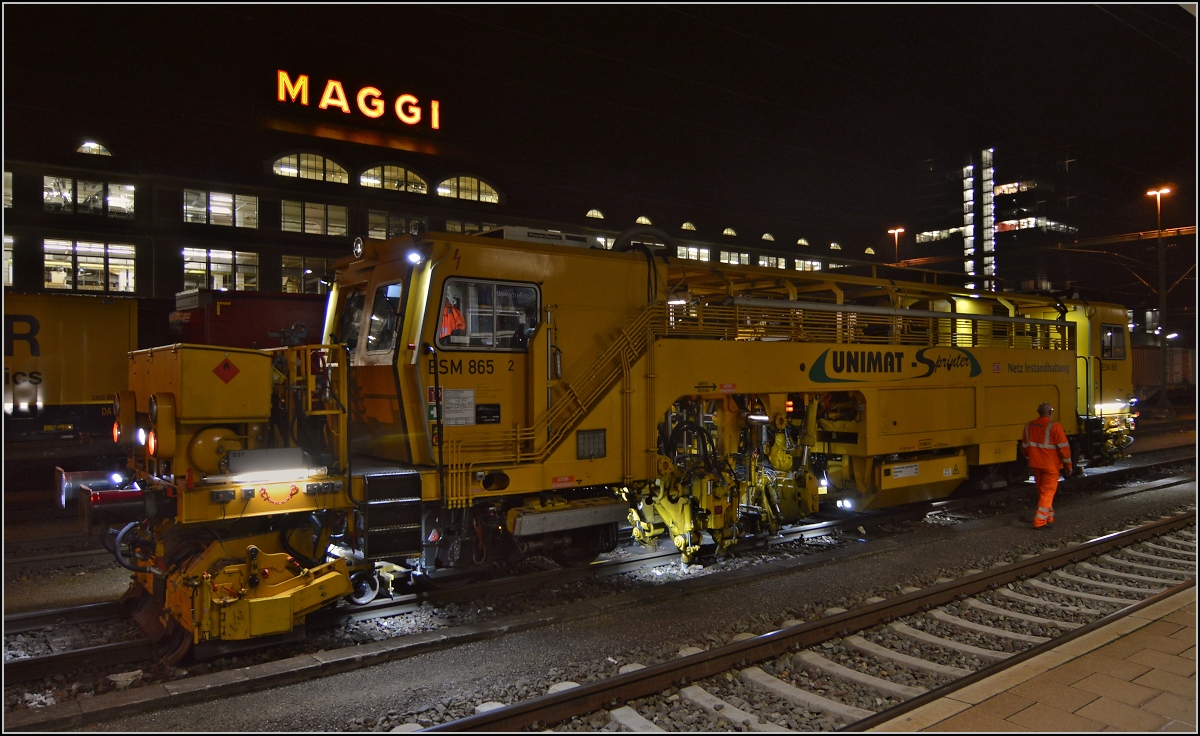 Gleisstopfmaschine Unimat Sprinter der DB Netzinstandhaltung in Aktion vor der Kulisse der Maggi-Werke in Singen. Oktober 2014.
