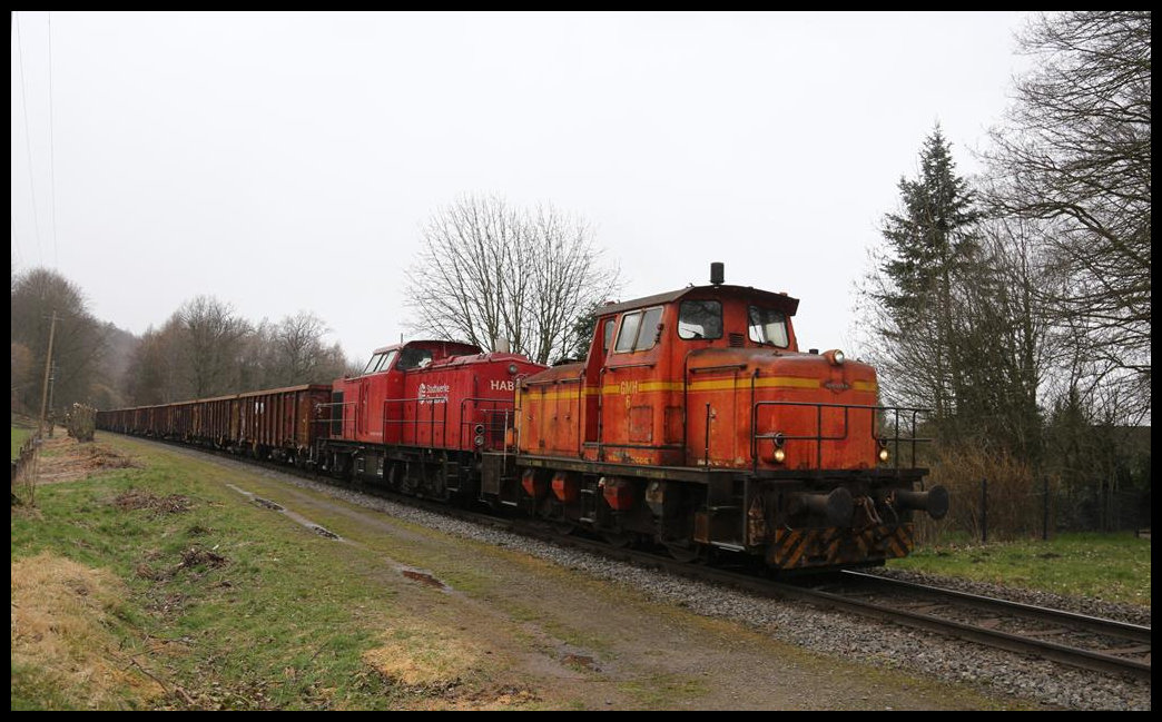 GMH 6 und Haba 8 sind hier am 11.03.2020 um 13.33 Uhr mit dem Schrottzug von Hasbergen nach Georgsmarienhütte zum Stahlwerk unterwegs. Wegen der schlechten Witterung leistet GMH 6 Vorspann Dienst und schleppt hier am Ortsrand von Ohrbeck zu Holzhausen den Zug über die Steigung am Augustaschacht.