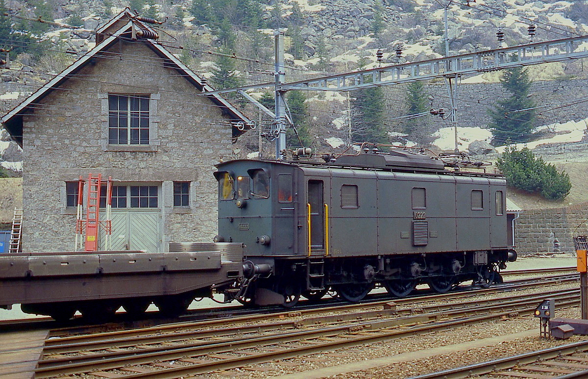 Gotthardbahn 1980: Im Mai 1980 näherte sich das Ende der Autozüge durch den Gotthardtunnel, denn mit der Eröffnung des Gotthard-Straßentunnels im September des gleichen Jahres wurde dieser Verkehr eingestellt. Bis zu diesem Zeitpunkt beförderten die in den Jahren 1922-25 in Dienst gestellten Ae 3/5 die Züge, auf dem Bild die Ae 3/5 10222 in Göschenen. Für diese Aufgabe erhielten die Lokomotiven u. a. eine Fernsteuerung, außerdem wurde der Ölhauptschalter durch einen Drucklufthauptschalter ersetzt. Damit dieser auf dem Dach untergebracht werden konnte, musste ein Stromabnehmer entfernt werden.