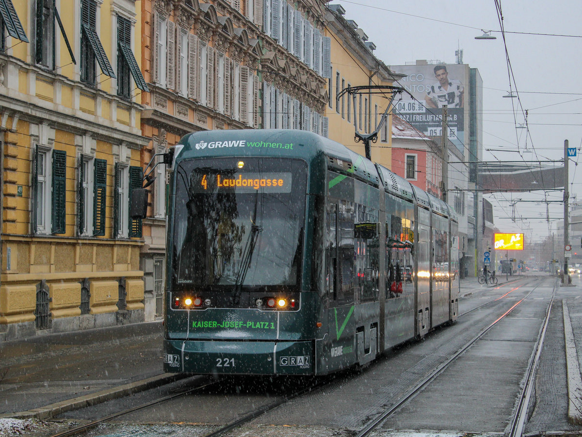 Graz. Am Nachmittag des 02.12.2020 gab es in Graz ein leichtes Schneetreiben, ehe in der Nacht auf den nächsten Tag 10 Zentimeter Neuschnee fallen. Variobahn 221 mit Werbung für Grawe Versicherung konnte ich als Linie 4 bei der Haltestelle Jakominigürtel/tim ablichten.
