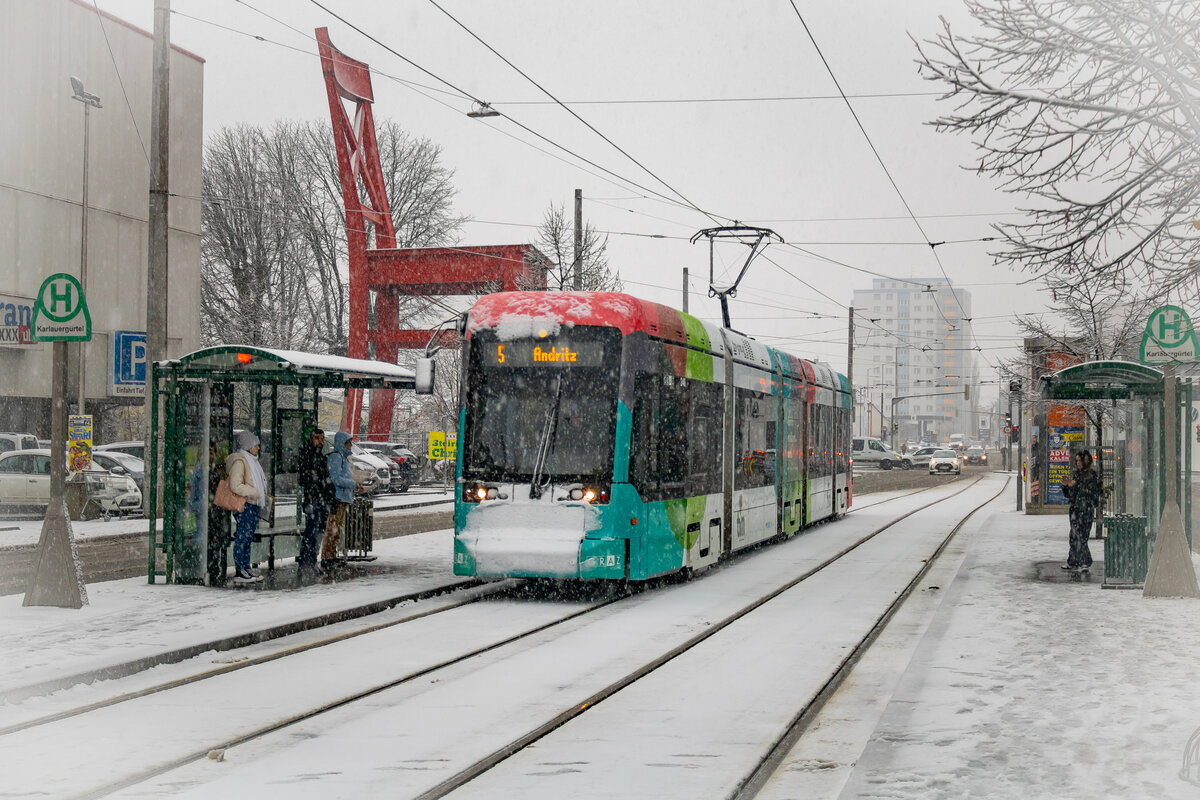 Graz. Am Vormittag des 02.12.2023 hat es in der steirischen Hauptstadt ordentlich geschneit – Variobahn 240 der Graz Linien ist hier als Linie 5 bei der Haltestelle Karlauergürtel zu sehen.