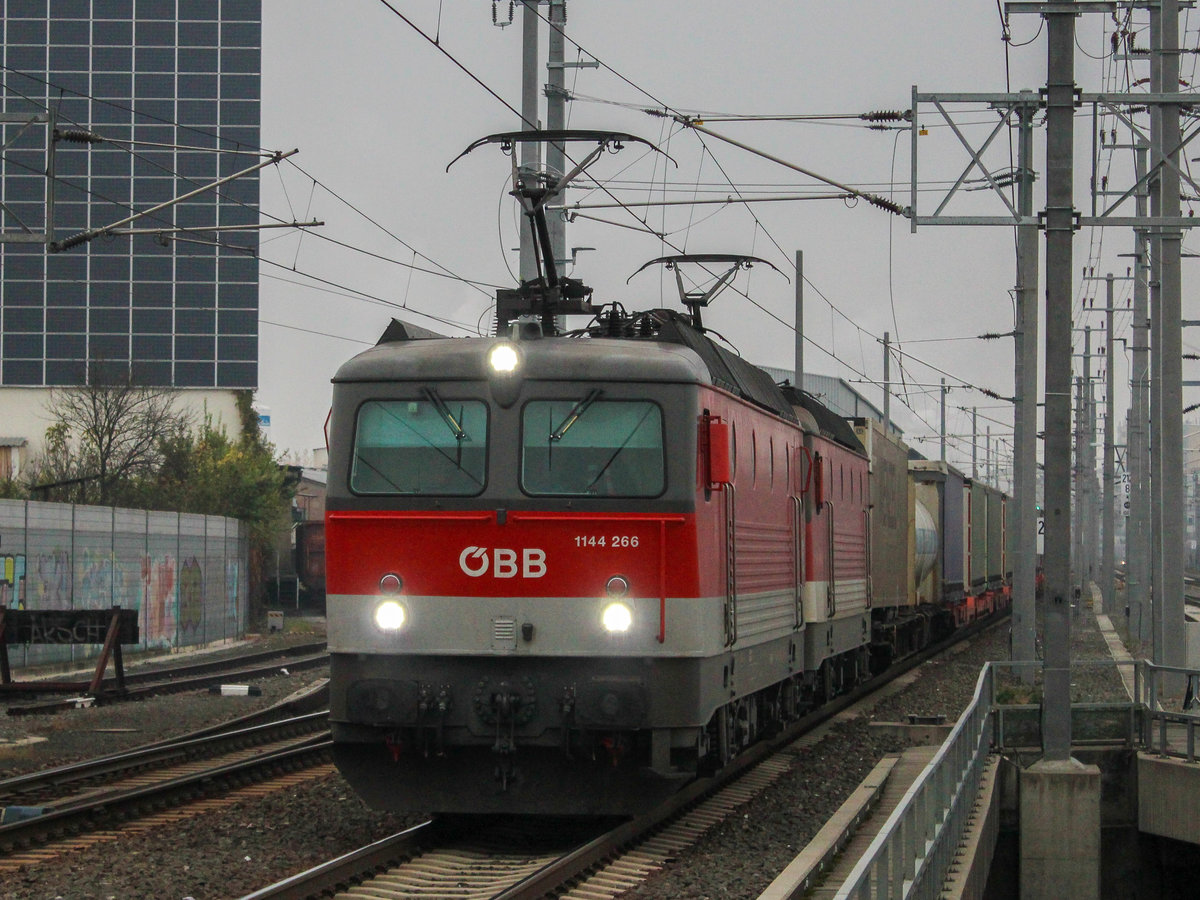 Graz. Durch dichten Nebel und typisches Novemberwetter am 09.11.2020 zieht die ÖBB 1144 266 gemeinsam mit einer Schwesterlok einen gemischten Güterzug durch Graz Don Bosco.