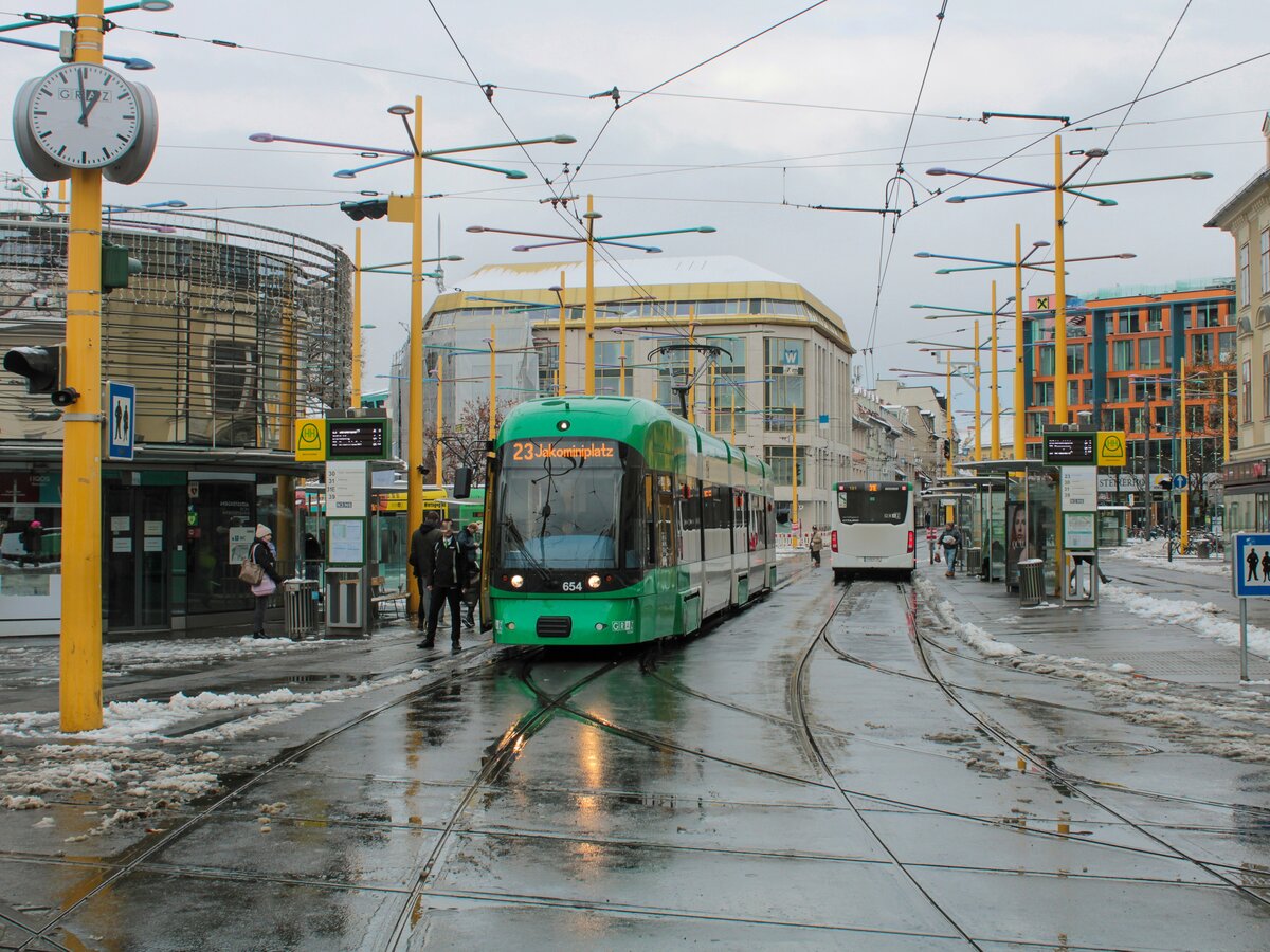 Graz. Mit der Einstellung der Linien 13 und 26 am 25.11.2021, ging direkt am Tag darauf die Linie 23 in Betrieb. Am 1. Betriebstag bei Tageslicht konnte ich Cityrunner 654 auf dieser am Jakominiplatz ablichten.