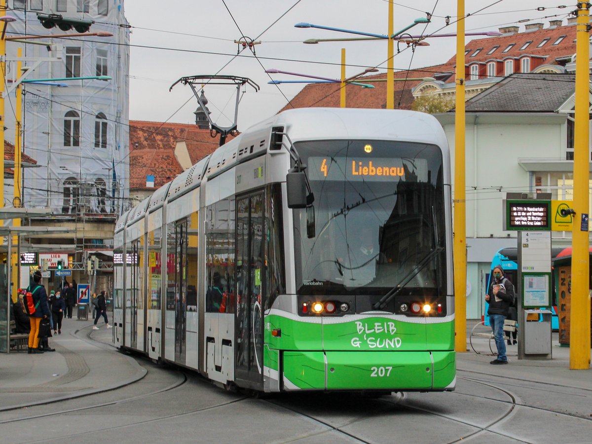 Graz. Seit 12.11.2020 sind mehrere Variobahnen mit einer Masken-Folierung an der Front unterwegs. Variobahn 207 konnte ich als Linie 4 am Jakominiplatz ablichten.