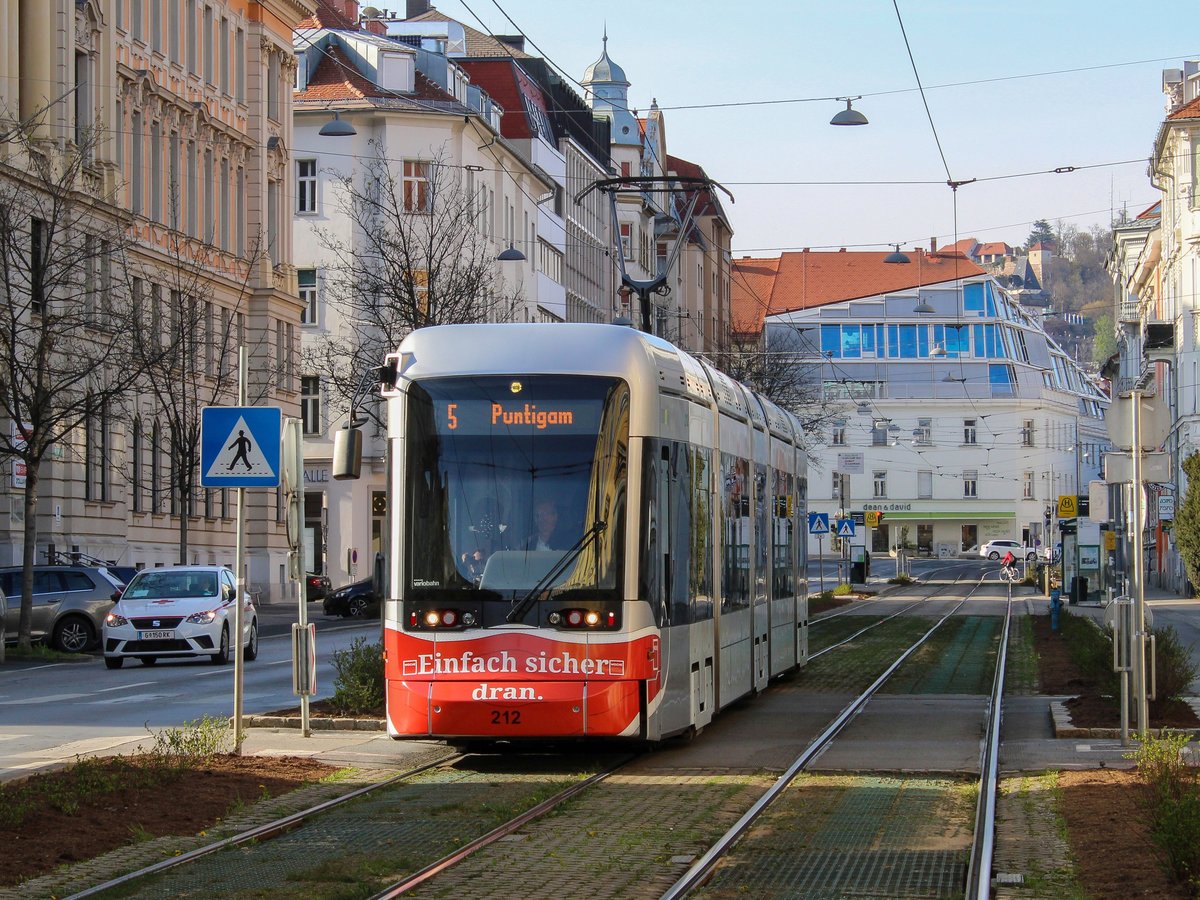 Graz. Variobahn 212 der Graz Linien mit Maske für die Woche-Zeitung war am 09.04.2021 auf der Linie 5 unterwegs, hier neben dem Finanzamt.