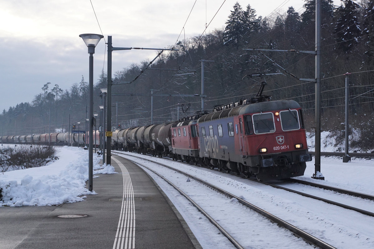 Güterzug 69468, Sonderleistung ab Langenthal bis Basel mit Re 10 in der Abenddämmerung bei Roggwil-Wynau am 18. Januar 2021.
An der Spitze dieses Zuges eingereiht ist die Re 620 047-1  Bex .
Foto: Walter Ruetsch