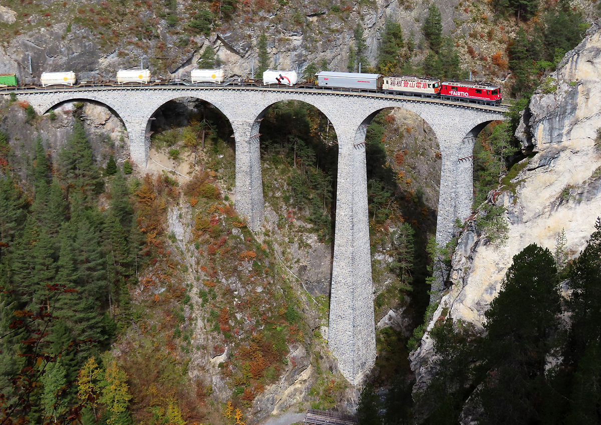 Güterzug auf dem weltberühmten Landwasserviadukt. An 2. Stelle die Lok mit den japanischen Schriftzeichen: Lok der Partnerbahn Hakone Tozan Railway