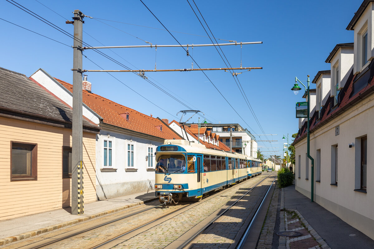 Guntramsdorf. Am vorletzten Augusttag 2026 fand die vorerst letzte geplante Fahrt der Baureihe 100 bei der Badner Bahn statt. Am 30.08.2026 wurde noch zwei Garnituren f�r einen Abschied auf die Strecke geschickt.
Triebwagen 126 bef�hrt hier die Feldgasse, eine bekannte Fotostelle in der Gemeinde, da hier bis vor wenigen Jahren noch mitten durch das Wohngebiet auf den Stra�enbahntrasse ebenfalls G�ter per Schiene durch die �BB transportiert wurden.