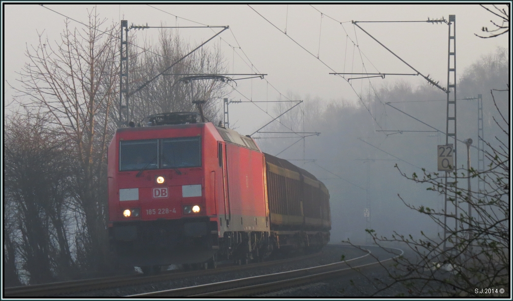 Guten Morgen Sonnenschein! Hier kämpfen sich gerade die ersten Strahlen des Tages durch den Frühdunst bei Rimburg an der Kbs 485.Die 185 228-4 ist mit ihrer Güterfracht unterwegs nach Aachen. Szenario vom 12.März 2014.