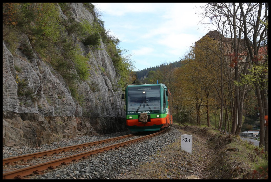 GW Train Regio Swinger 818248-7 aus Karlsbad erreicht hier am 28.4.2024 um 9.29 Uhr Becov nad Teplou. Verdeckt durch Baumbewuchs ist im Hintergrund die gleichnamige Burg der Stadt zu erkennen.