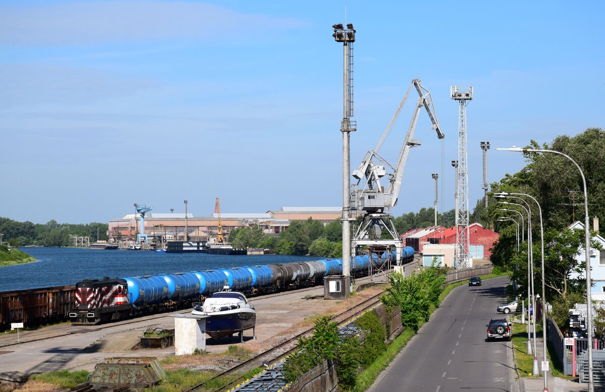 Hafen-Sichtung in Komárno (Komárom) in der Slowakei. Die TransLog Slovakia Lok 742 087 ist mit einem Kesselwagenzug fährt ein in die Hafen. Im Hitergrund ist die Schiff Fabrik von Komárno. 
01.05.2024.