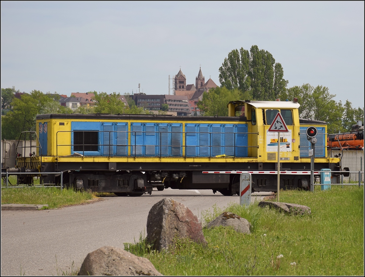 Hafenbahn Colmar/Neu Breisach. BB 2000 kurz vor dem Tor zum Hafengelände. Im Hintergrund ist bereits Deutschland mit dem Münster von Breisach zu sehen. Volgelsheim, April 2019.