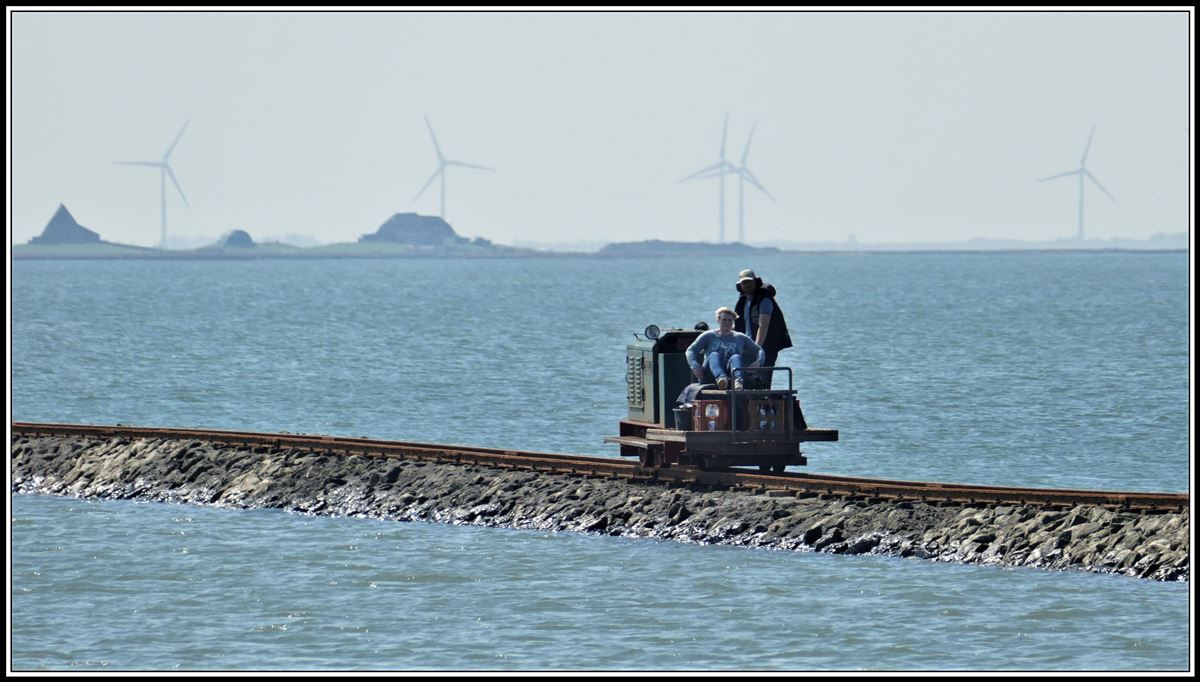 Halligbahn Lüttmoorsiel - Nordstrandischmoor. 600mm Spurweite und 3,6km lang. Neben den erhöhten Höfen auf der Hallig Nordstrandischmoor kommt auf dem Damm eine Lore entgegen. (19.05.2019)
