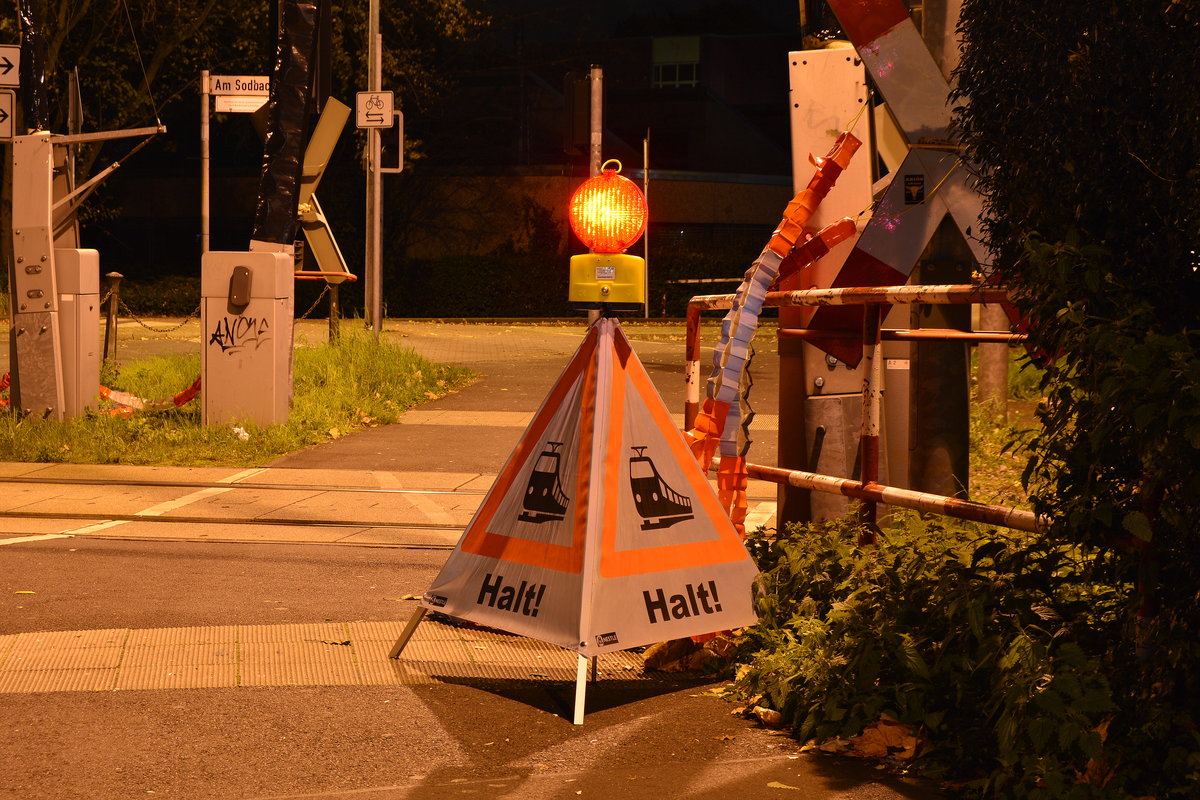 HALT Zugverkehr. Doch nicht nur diese Schilder signalisieren die Zugfahrt. Der Bahnübergang wird auch zusätzlich mit Flatterband gesichert. Grund dieser Sicherung sind die Bauarbeiten am 22.10.2017 wenn die Bodan Platten durch Strail Gummiplatten ersetzt werden.

Grevenbroich 21.10.2017