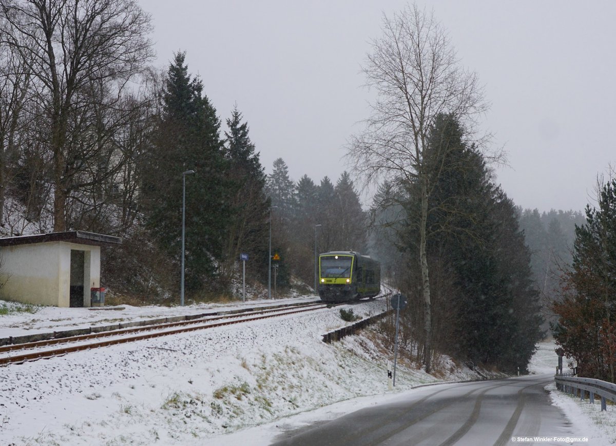 Haltestelle Rothenbürg bei Selbitz. Am 09.12.2017 kommt der AG 650 von Hof her den Berg herunter. Nicht mehr für alle Züge ist das ein Bedarfshalt aktuell. Vor wenigen Jahren hat man modernisiert und hier etliche neue Lampen, das Informationssystem und neue Stationschilder aufgestellt.  Früher, zu Bundesbahnzeiten, da stand der Ortsnahme nur am Häuschen und es standen maximal 3 oder 4 Glühlicht-Funzellampen. War aber schööön idyllisch mit dem Schienenbus....
