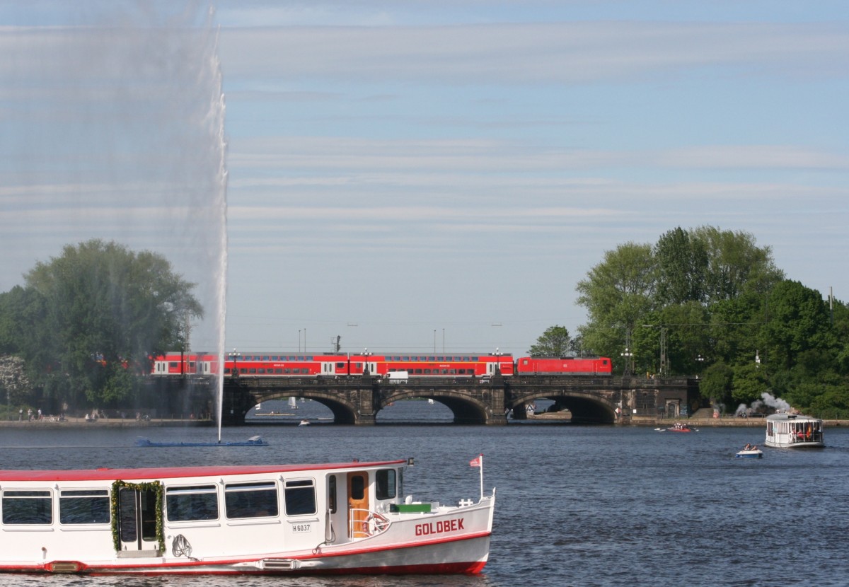 Hamburg pur: Whrend die MFS  Goldbek  und das Museumsdampfschiff  St. Georg  ber die Binnenalster schippern, ist 112 xxx mit RE 21025 (Kiel Hbf–Hamburg Hbf) und 23 Minuten Versptung auf der Lombardsbrcke unterwegs (18.05.2012).