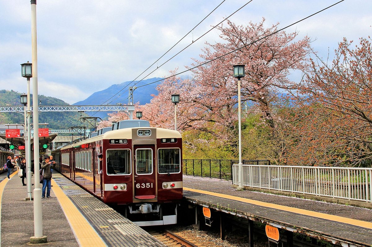 Hankyû-Konzern, Arashiyama Linie: Der Hankyû-Konzern (Spurweite 1435 mm) mit Ausgangspunkt in Ôsaka betreibt ein sehr grosses S-Bahnnetz, das hauptsächlich die Städte Ôsaka und Kôbe, Ôsaka und Takarazuka, und Ôsaka und Kyôto verbindet. Kurz vor Kyôto zweigt eine 4,1 km lange Zweiglinie nach Arashiyama ab, flussaufwärts in die Berge, die für ihre wunderbaren Kirschblüten berühmt sind. Die Züge des Hankyû-Konzerns gehören zu den am besten gepflegten und polierten Züge Japans. Im Bild steht Zug 6351 in Arashiyama, 8.April 2015; leider ist die Kirschblüte bereits am Abfallen. 