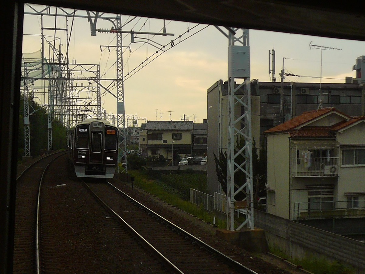 Hankyû-Konzern, Begegnung mit Zug 9306 (Serie 9300, gebaut 2003-2010) am frühen Morgen bei der Ausfahrt aus der Agglomeration Kyôto, 28.September 2009. 
