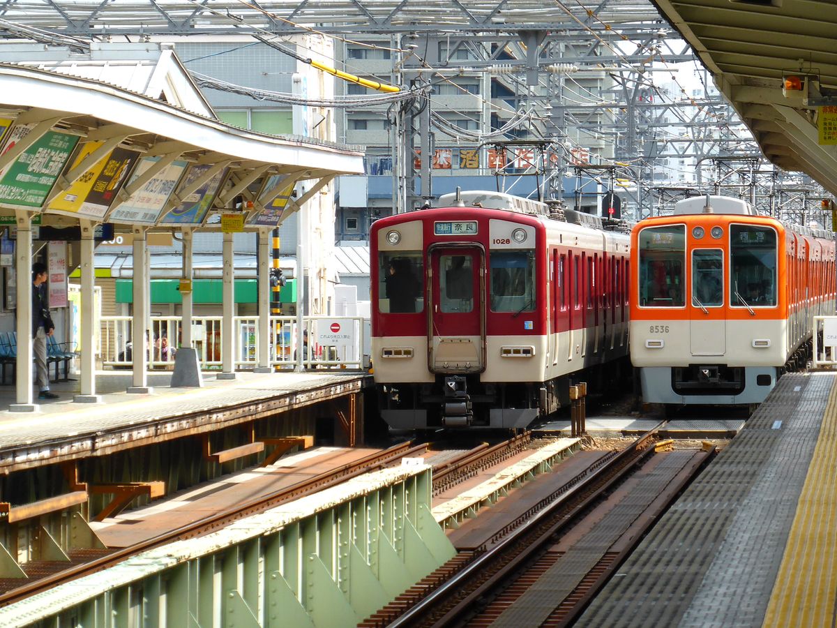 Hanshin Konzern / Kintetsu Konzern: Seit Züge des Hanshin Konzerns über die Kintetsu-Strecke durch Ôsaka hindurch bis zur Stadt Nara durchfahren können und damit eine gute normalspurige West-Ost-Verbindung durch den ganzen Siedlungsraum des Kansai-Gebiets herstellen, kommen zum Ausgleich Züge des Kintetsu Konzerns über die Hanshin-Strecke bis zur Stadt Kôbe. Im Bild kreuzen sich in Mukogawa ein Kintetsu-Zug (1028) und ein Hanshin-Zug (8536, mit Ersatz-Endwagen für den im Erdbeben zerstörten 8236), 22.März 2014. 