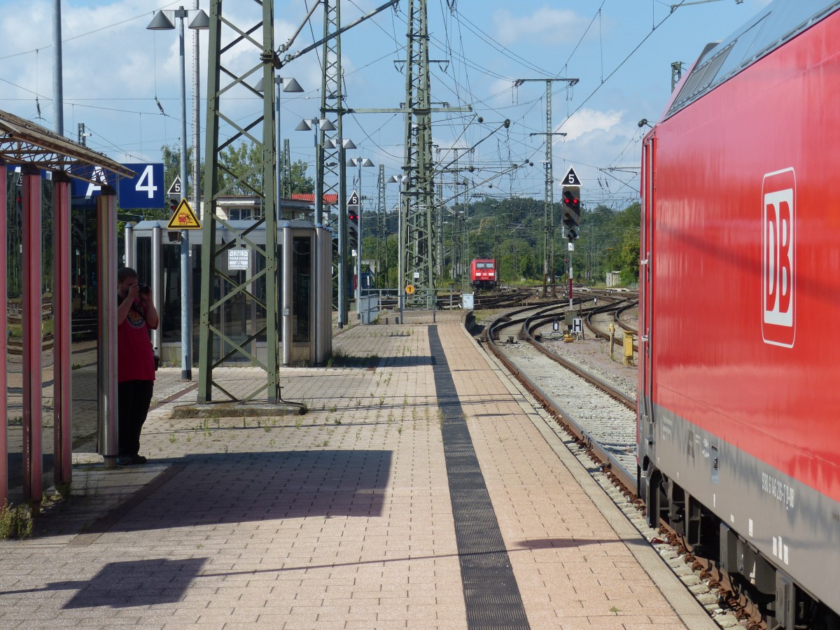 Hanspeter tarnt sich in Bahnfarben und nutzt die Bahnhofsmgebung elegant als Versteck. Aber ertappt. Hier fotografiert er eine Lok der Schwarzwaldbahn. 2.8.2015