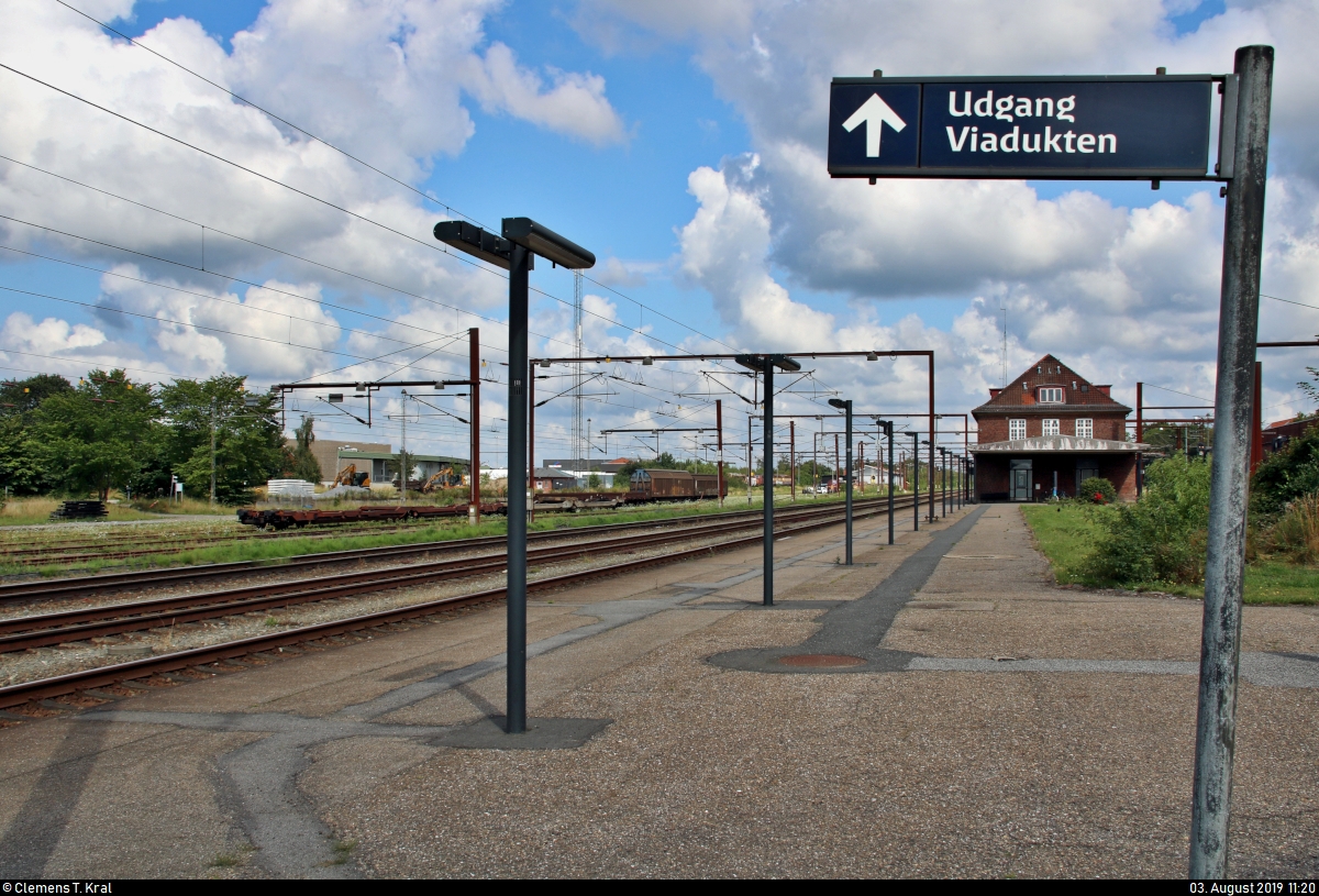 Hat man den Weg von der Straße Nørregade zum Bahnhof Padborg st (DK) auf der Bahnstrecke Fredericia–Flensburg (KBS 65 (DSB)) hinter sich gelassen, erreicht man den Bahnsteig 1/2 mit Blick auf die Abstell- und Gütergleise.
Ein Wegweiser zeigt den Fahrgästen ebenso bereits den Ausgang auf der anderen Seite.
[3.8.2019 | 11:20 Uhr]